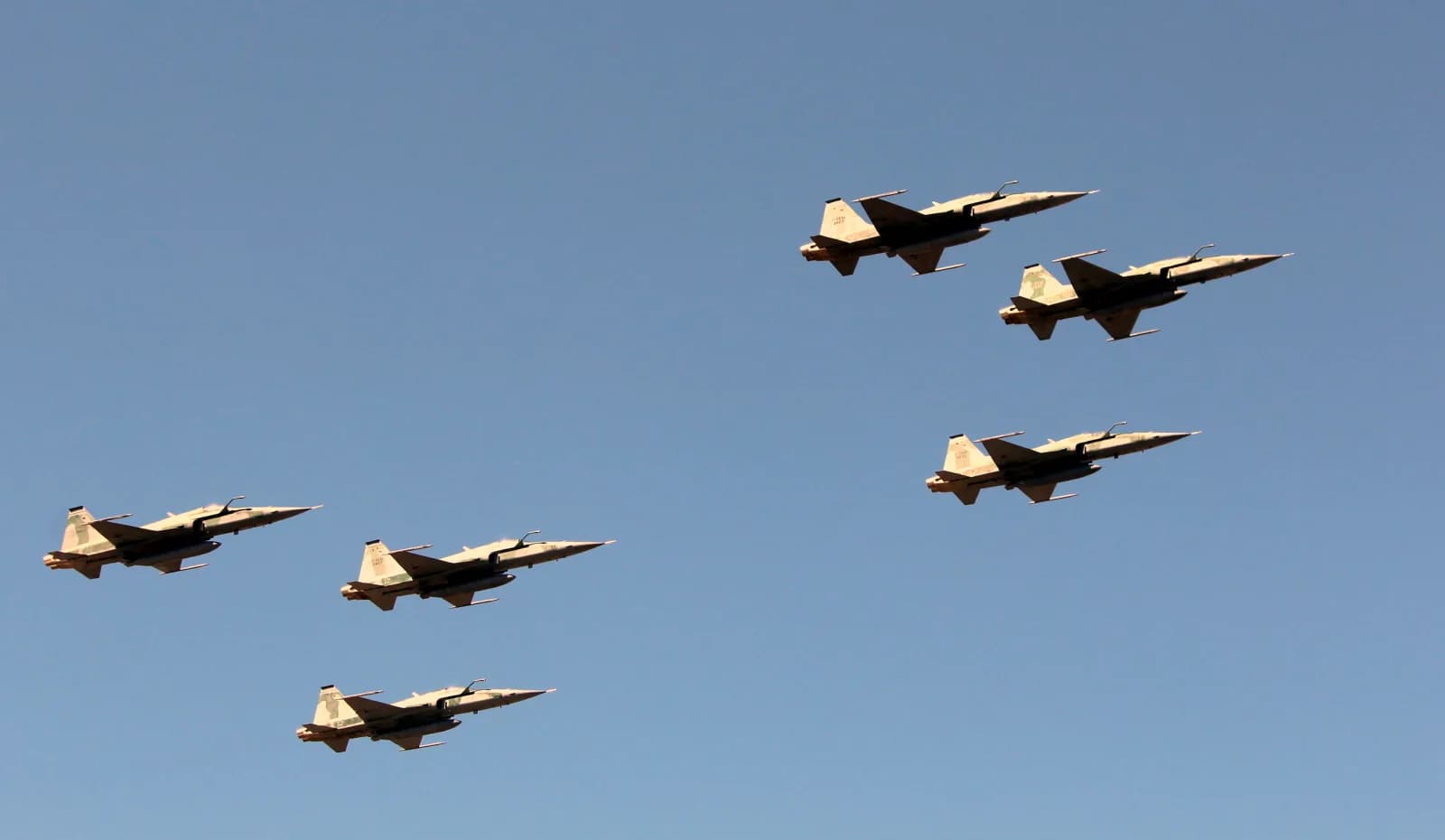 Seis caças F-5EM da Força Aérea Brasileira em formação contra o céu azul
