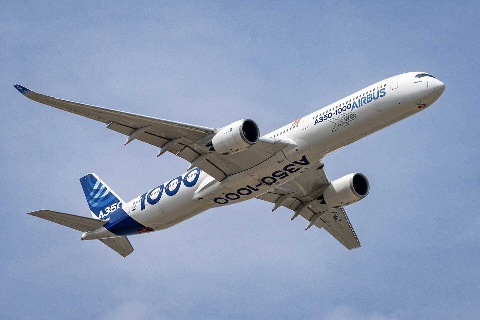 Airbus A350-1000 com a pintura da fabricante em curva no céu azul, trem de pouso recolhido