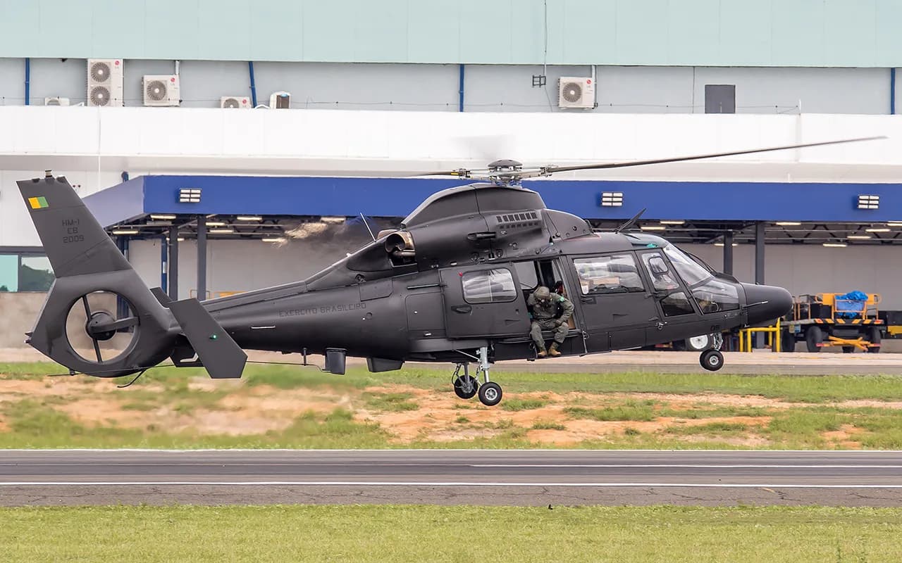 Helicóptero HM-1 Pantera do Exército Brasileiro, cinza-escuro, pairando baixo sobre a pista de um aeroporto